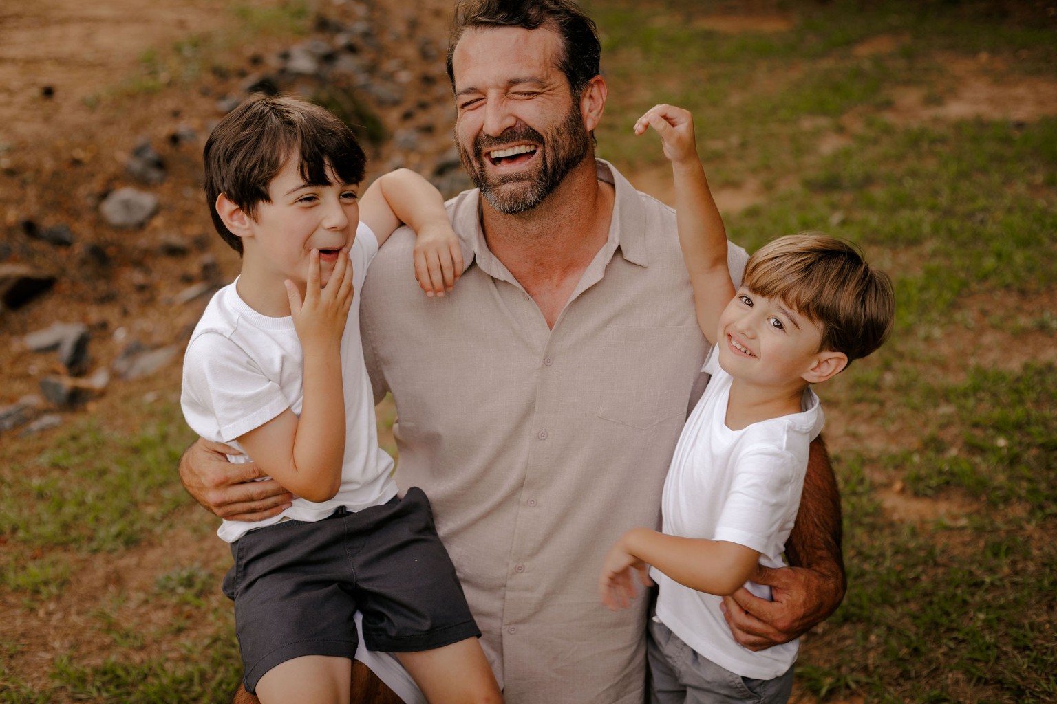 A father laughing with his two children