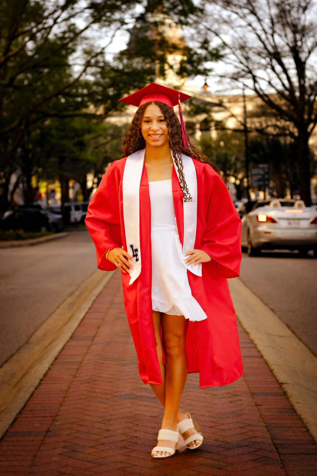 Layla walking confidently in her red graduation gown